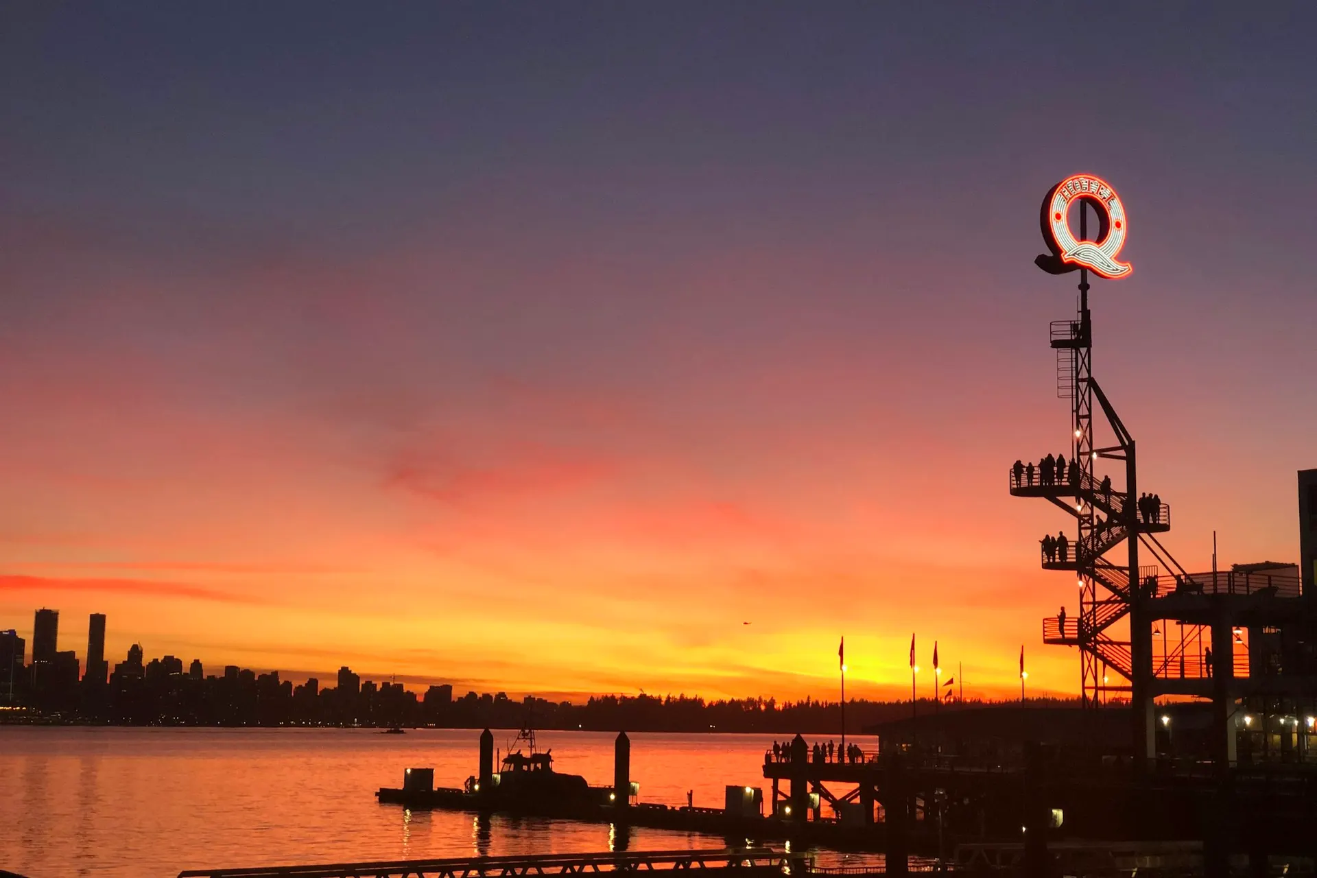 The Lonsdale Quay pier at sunset in North Vancouver, the Vancouver skyline across the water.